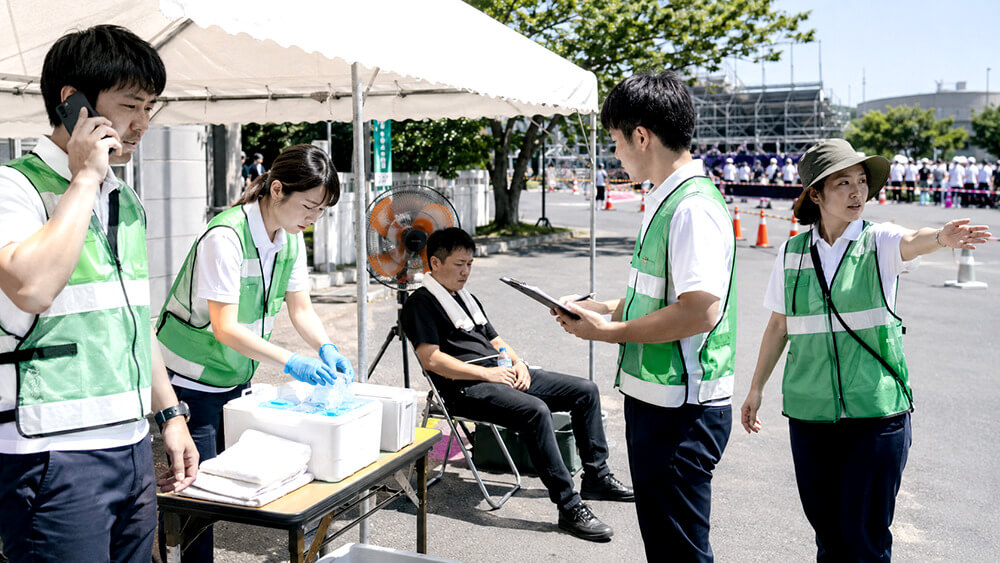 体調不良者への初動対応で役割分担する現場スタッフ
