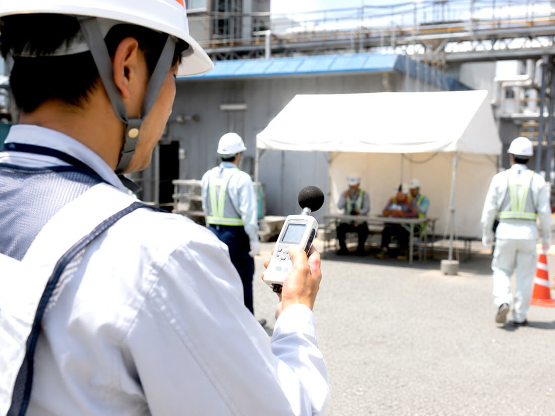 屋外作業現場でWBGT計を確認する安全管理担当者
