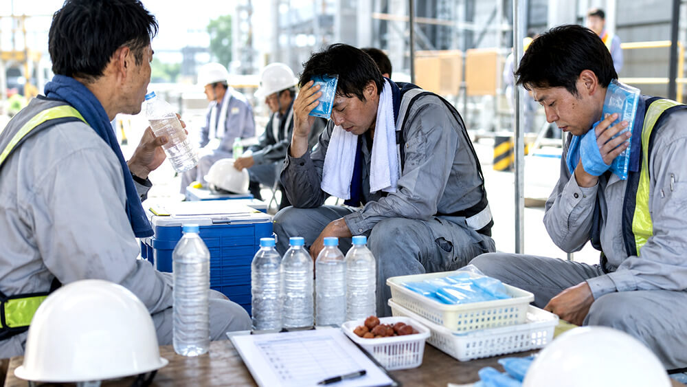 熱中症対策で休憩中に水分塩分補給を行う現場