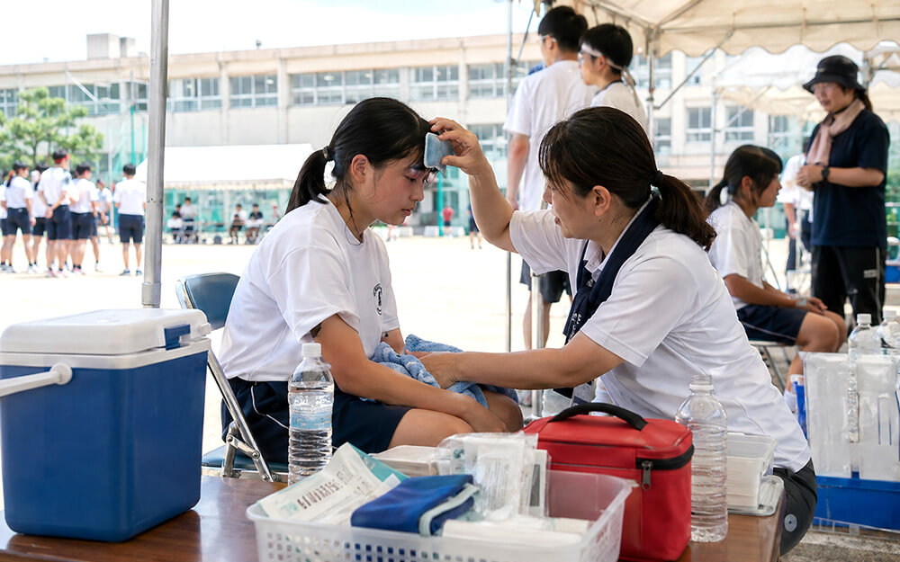 学校やイベント会場で熱中症対応を行うスタッフのイメージ
