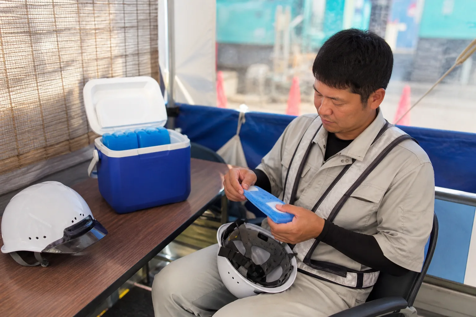 休憩所でヘルメット用冷却ジェルを交換するイメージ