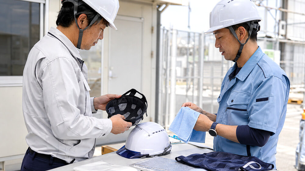 ヘルメット作業の熱中症対策としてインナーやタオルを確認する作業者