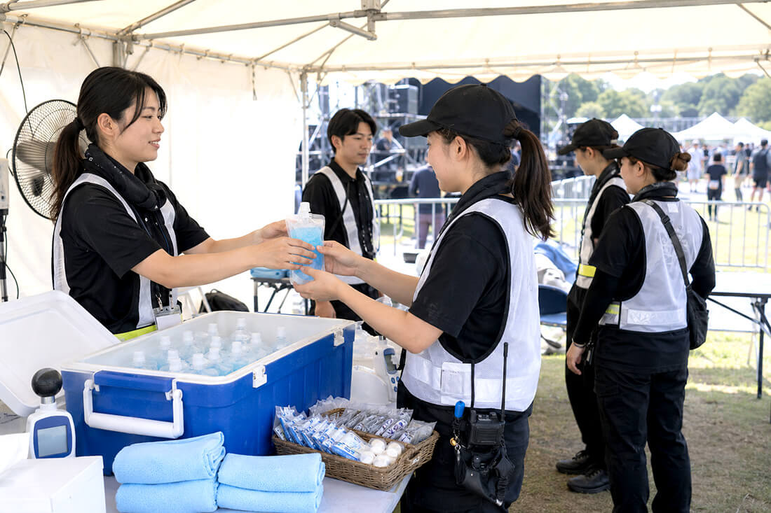 屋外イベントスタッフにアイススラリーを配布する様子