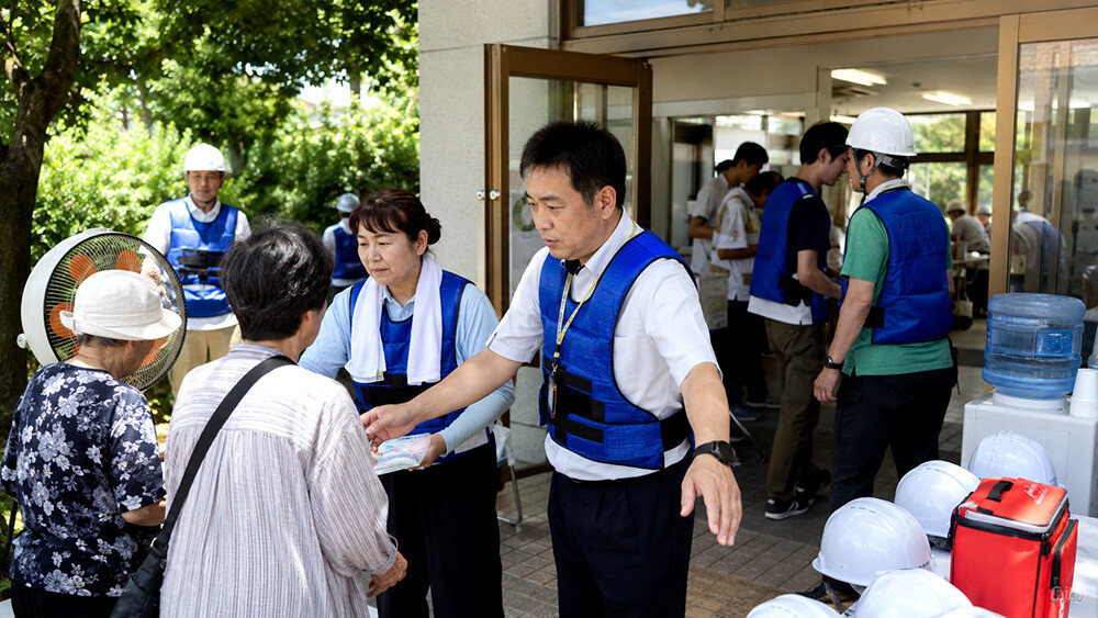 避難所運営スタッフが冷却ベストを着用して物資対応を行う様子