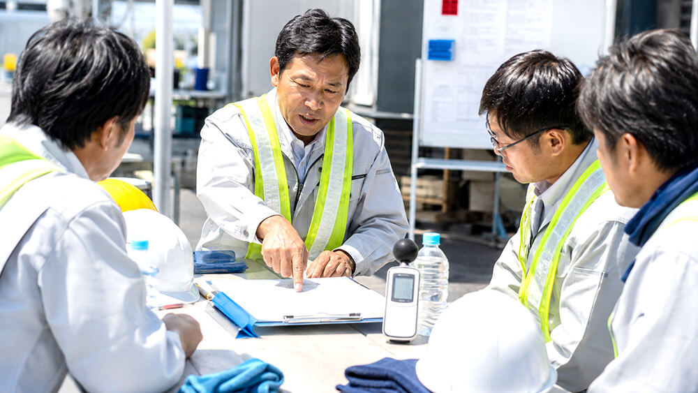 WBGT計と作業中止判断チェックリストを確認する様子